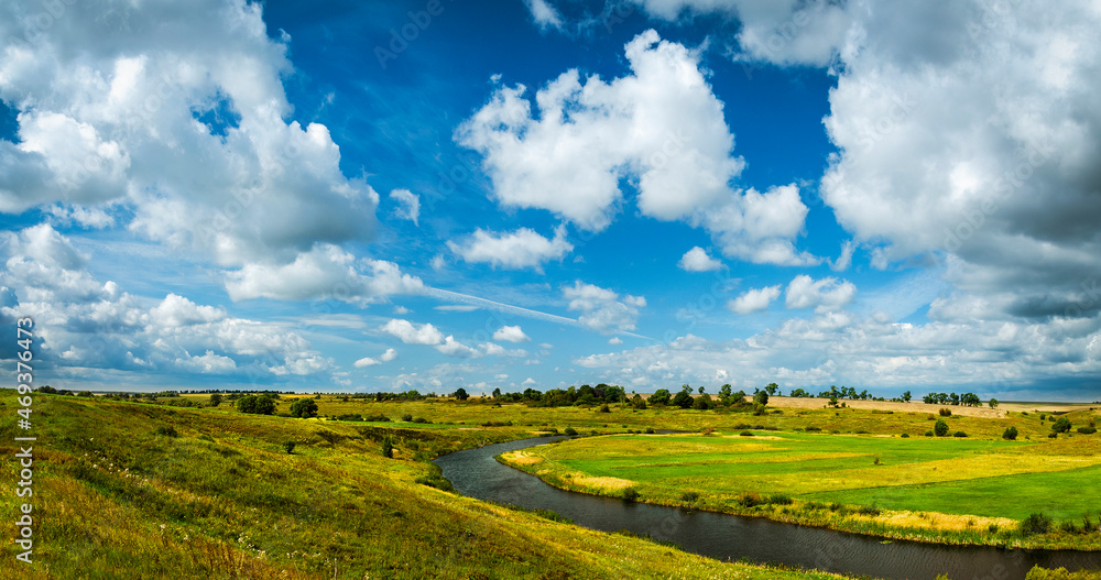 Summer landscape with river and green fields