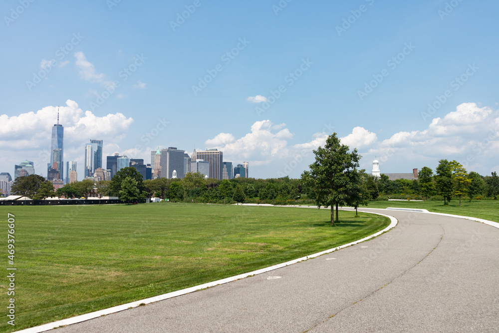 Lower Manhattan Skyline seen from a Green Grass Field and Road on Governors Island in New York City during the Summer