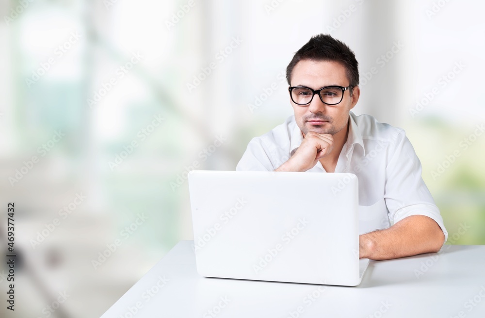 Portrait of handsome young man student watching online webinar using laptop Portrait of handsome young man student watching online webinar using laptop