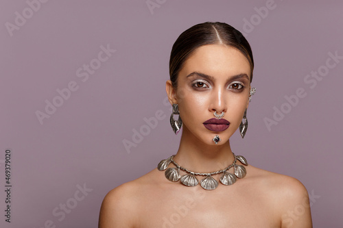 Beauty Portrait of a beautiful fashion girl with sensual marsala lips, make-up, jewelery, hairstyle. Copy space.