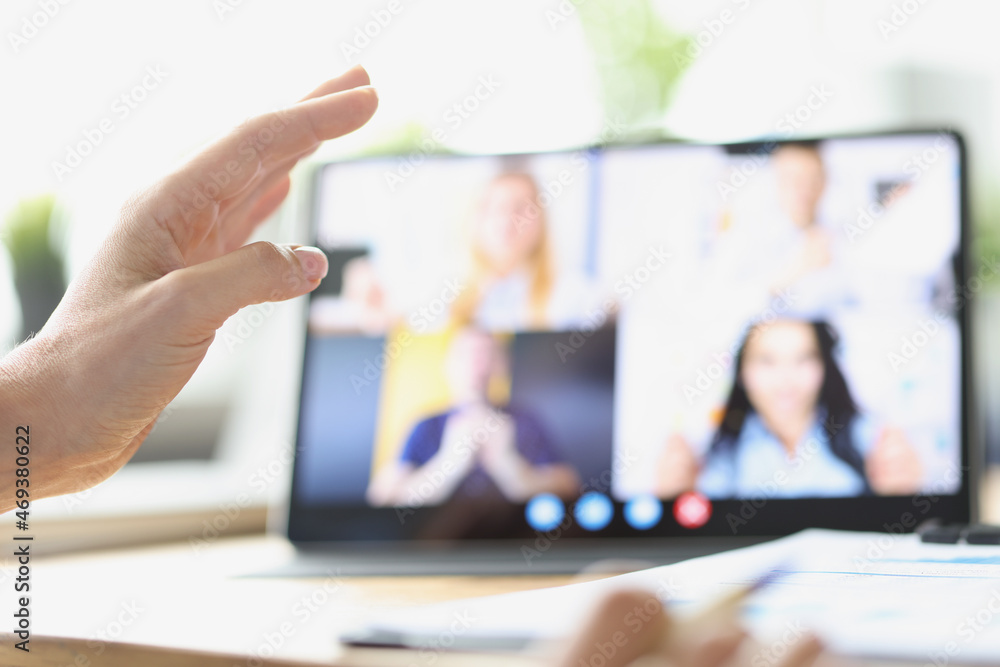 Female hand on background of tablet with video call from employees Female hand on background of tablet with video call from employees