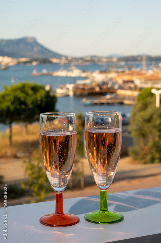 Summer party, drinking of French champagne rose sparkling wine in glasses with view on fishermen harbour of Toulon, France Summer party, drinking of French champagne rose sparkling wine in glasses with view on fishermen harbour of Toulon, France