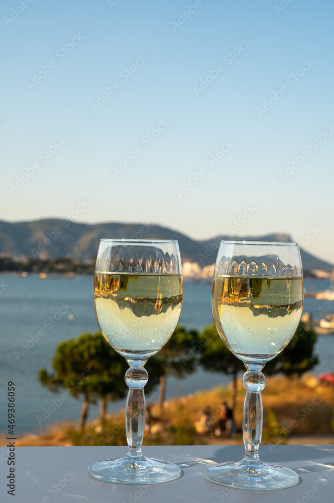 Obraz premium Summer on French Riviera, drinking cold white wine from Cotes de Provence on outdoor terrase with view on harbour of Toulon, Var, France