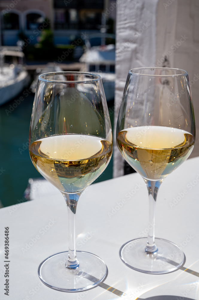 Summer on French Riviera Cote d'Azur, drinking cold dry white wine from Cotes de Provence on outdoor terrase in Port Grimaud, Var, France Summer on French Riviera Cote d'Azur, drinking cold dry white wine from Cotes de Provence on outdoor terrase in Port Grimaud, Var, France