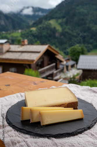 Cheese collection, French cow cheese comte, beaufort, abondance and french mountains village in Haute-Savoie on background photo