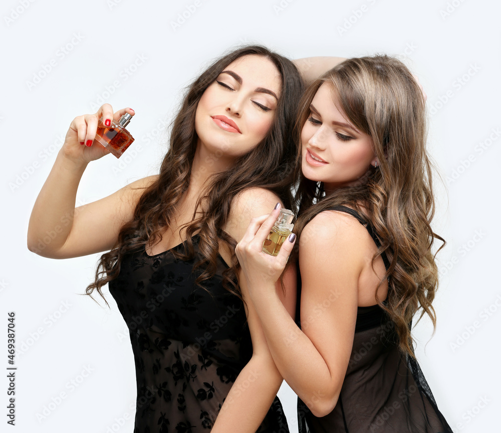 Perfume. Young girls smelling aroma with pleasure Perfume. Young girls smelling aroma with pleasure