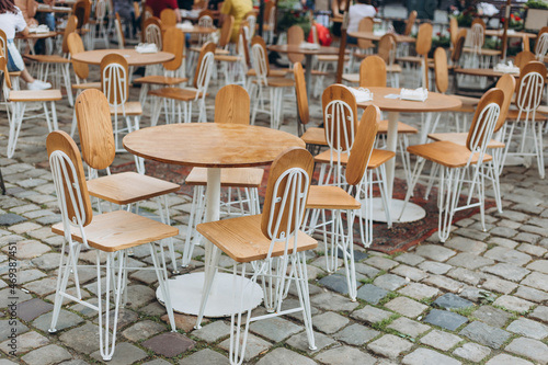 Empty chairs in outdoor cafe or restaurant on summer day. Reastaurant tables waiting for customers, old town