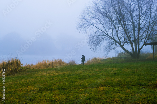 Fisherman on the pond in a fog