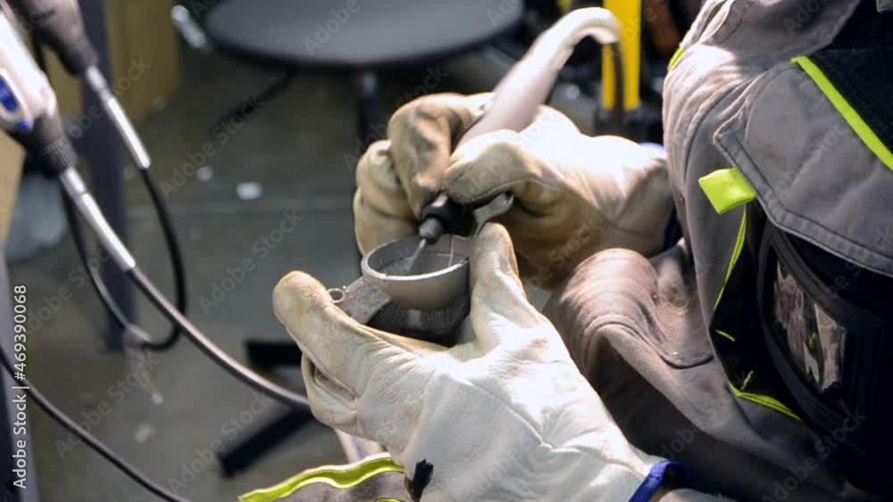 Man in work uniform grinds metal detail by hand close-up. Grinding metal detail Man in work uniform grinds metal detail by hand close-up. Grinding metal detail