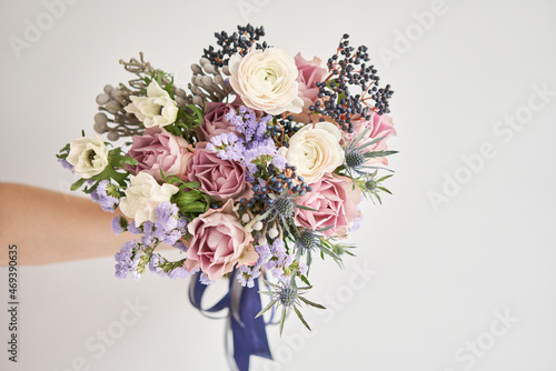 Beautiful bouquet of mixed flowers with ranunculus clooney hanoi in woman hand. Floral shop concept . Beautiful fresh cut bouquet. Flowers delivery photo