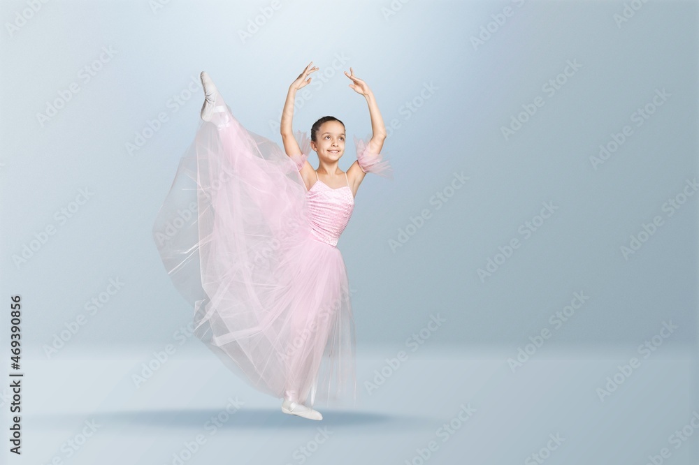 Naklejka premium Tips on toes. Young graceful ballerina dancing alone on background.