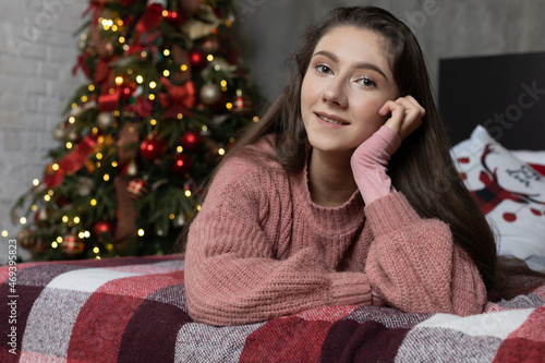Beautiful young girl on the background of the Christmas interior. © malinaphoto