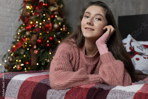 Beautiful young girl on the background of the Christmas interior. © malinaphoto