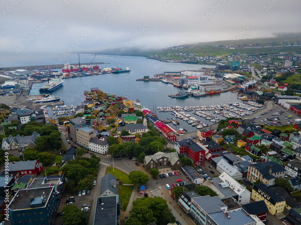 Obraz premium Beautiful aerial view of the City of Torshavn Capital of Faroe Islands- View of Cathedral, colorful buildings, marina, suburbs and Flag