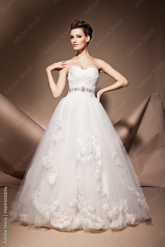 The beautiful young woman posing in a wedding dress The beautiful young woman posing in a wedding dress