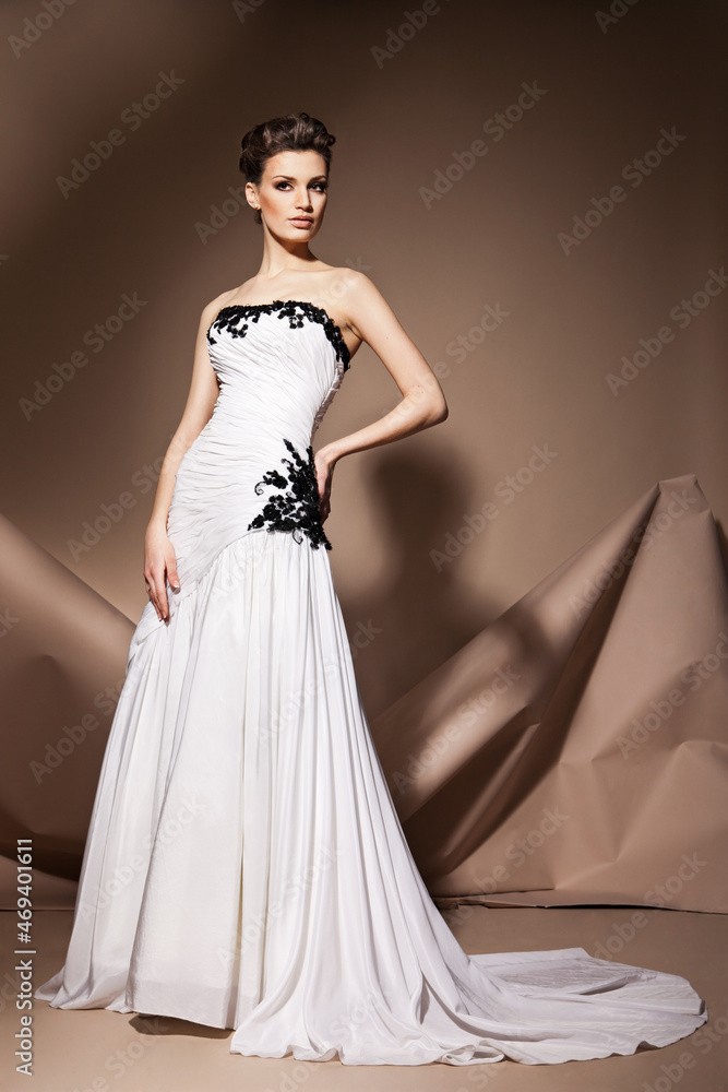 Fototapeta premium The beautiful young woman posing in a wedding dress