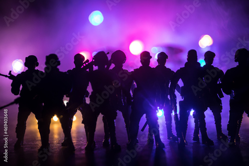 Anti-riot police give signal to be ready. Government power concept. Police in action. Smoke on a dark background with lights. Blue red flashing sirens. Dictatorship power photo