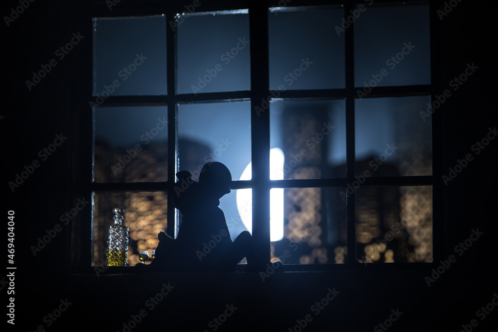 Fototapeta premium A realistic dollhouse living room with furniture and window at night. Romantic couple sitting on window. Artwork table decoration with handmade realistic dollhouse. Selective focus.
