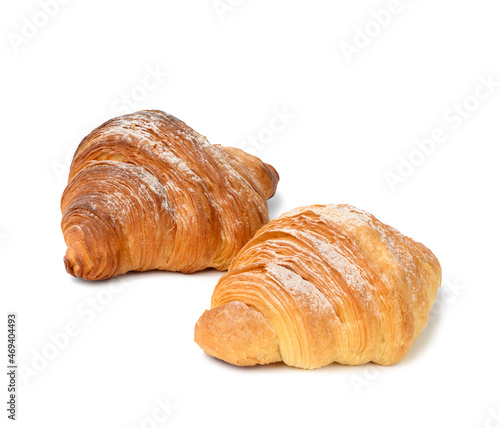 two baked croissants on a white isolated background, dessert for breakfast sprinkled with powdered sugar