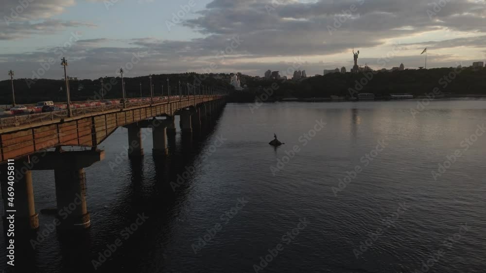High angle view of river Dnipro and a long bridge with lots of traffic over it