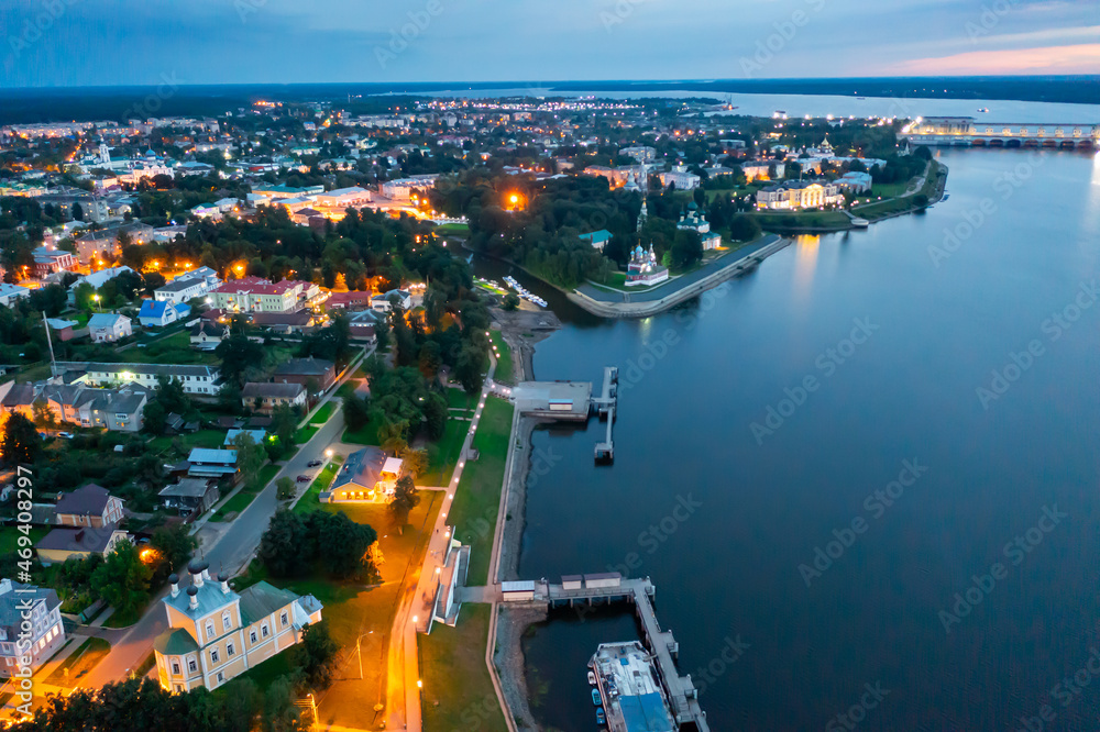 Scenic general aerial view of lighted Russian town of Uglich on banks of Volga River on summer evening, Yaroslavl Oblast