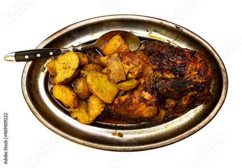 Just cooked roasted chicken served on metal dish with fried potatoes. Isolated over white background