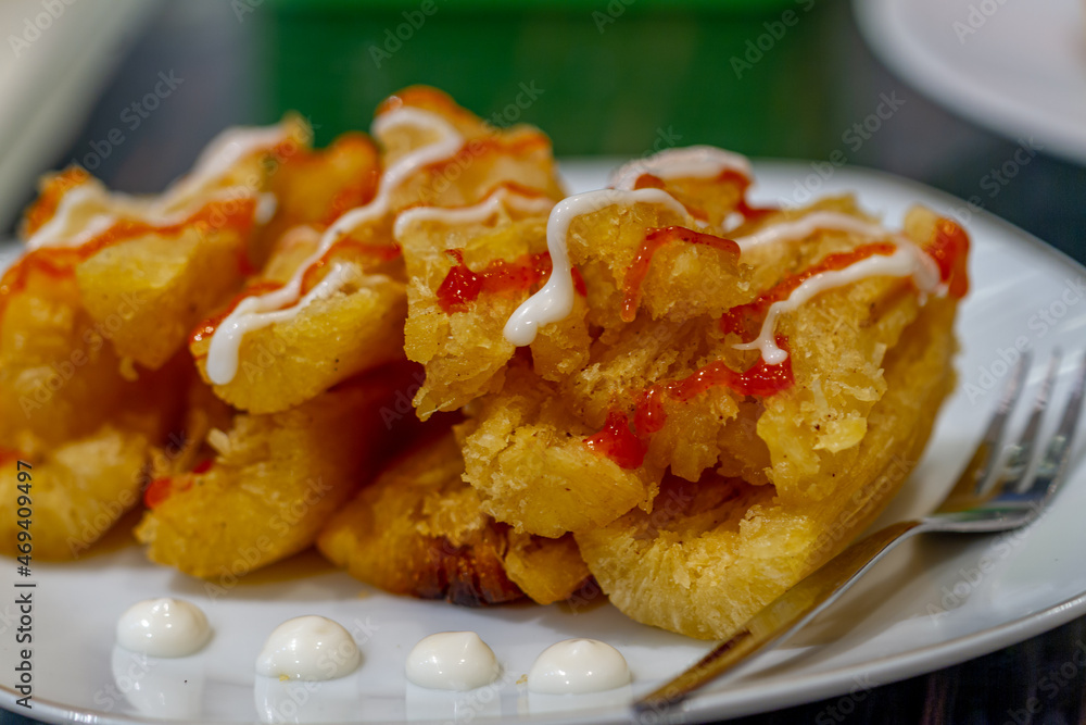 Fried cassava served with cafe-style sauce and mayonnaise, usually consumed with tea or coffee, oily and high-calorie Fried cassava served with cafe-style sauce and mayonnaise, usually consumed with tea or coffee, oily and high-calorie