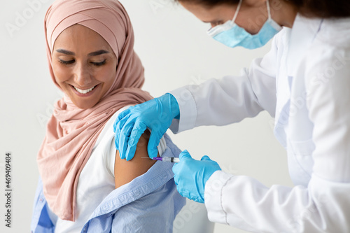 Closeup Shot Of Female Doctor Making Coronavirus Vaccine Injection To Muslim Woman