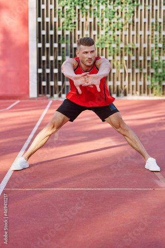 athletic man in red jersey on the sports ground exercise