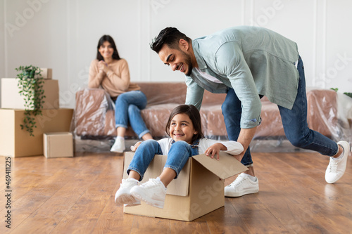 Happy middle eastern family riding in cardboard box