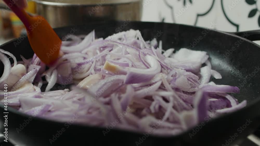 Frying caramelized onion inside black frying pan on gas stove. Frying caramelized onion inside black frying pan on gas stove.