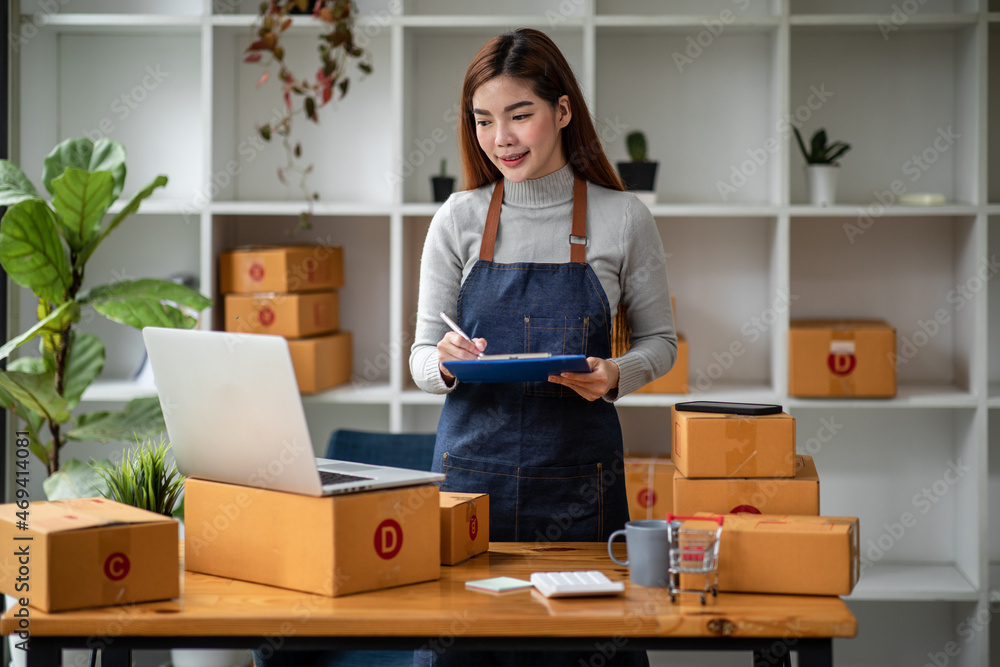 Portrait of Starting small businesses SME owners female entrepreneurs working on receipt box and check online orders to prepare to pack the boxes, sell to customers, sme business ideas online. Portrait of Starting small businesses SME owners female entrepreneurs working on receipt box and check online orders to prepare to pack the boxes, sell to customers, sme business ideas online.