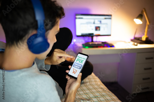 Foto Young man shopping online at home and paying via PIX