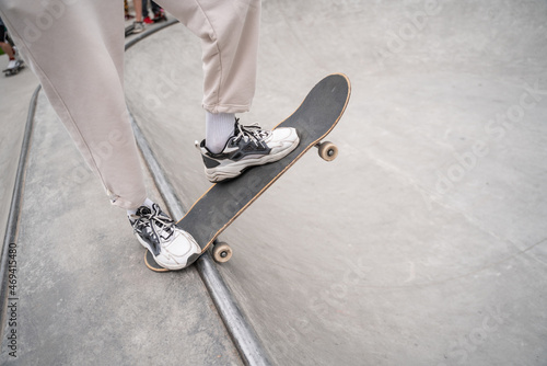 partial view of man in sneakers skating on skate ramp.