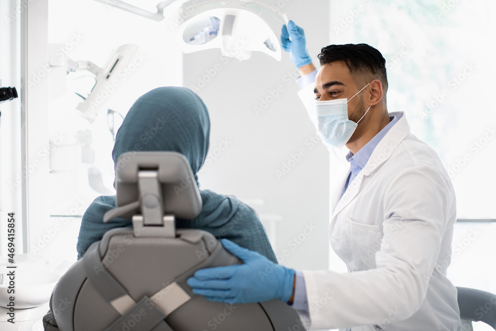 Modern Stomatology. Arab Dentist Doctor Having Check Up With Muslim Female Patient