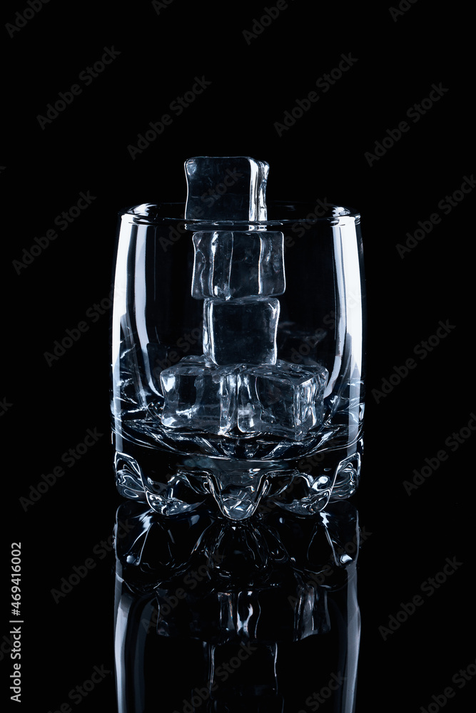 Empty glass filled with ice cubes o na black background