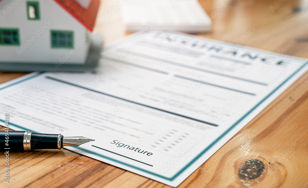 Obraz premium Closeup pen and house model on Insurance policy document.