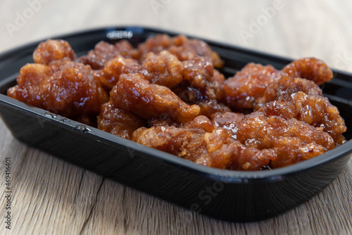 Bowl of crispy breaded orange chicken smothered in a spicy sauce for great Chinese fast frood.