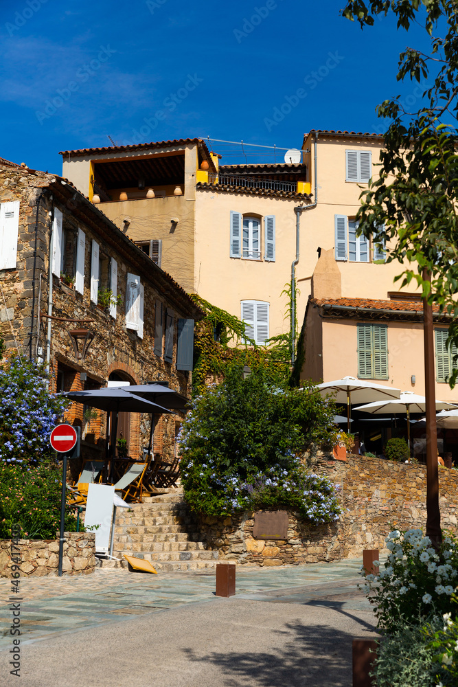 Scenic view of medieval Provencal village of Grimaud with ancient stone buildings on narrow flowering cobbled streets on sunny fall day, France.