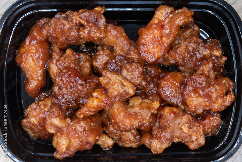 Overhead view of bowl of crispy breaded orange chicken smothered in a spicy sauce for great Chinese fast frood. Overhead view of bowl of crispy breaded orange chicken smothered in a spicy sauce for great Chinese fast frood.