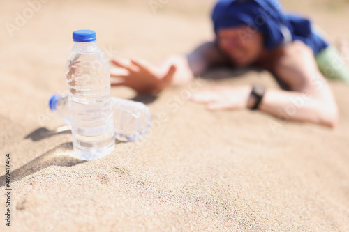 Man lying on sand in desert and feeling thirst