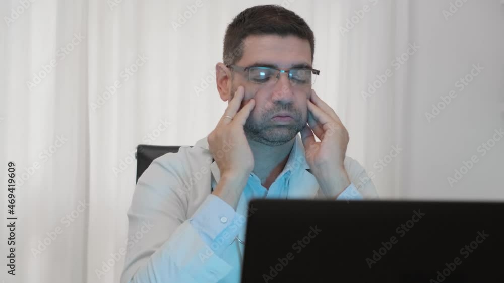 Portrait Of A Male Doctor In Eyeglasses Feeling Stressed While Sitting In Front Of The Computer. medium shot Portrait Of A Male Doctor In Eyeglasses Feeling Stressed While Sitting In Front Of The Computer. medium shot