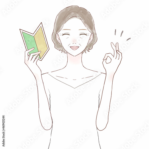 初心者マークを持ってOKサインを出す中年女性