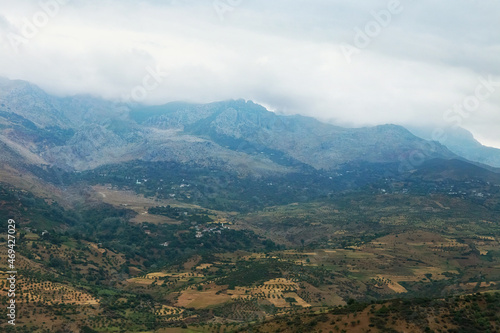 Moroccan landscape with foggy mountains and fields.