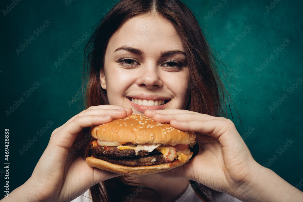 cheerful woman with hamburger near face snacking fast food cheerful woman with hamburger near face snacking fast food