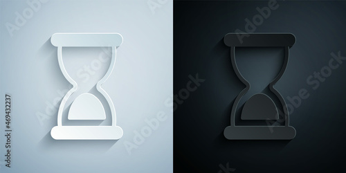 Paper cut Old hourglass with flowing sand icon isolated on grey and black background. Sand clock sign. Business and time management concept. Paper art style. Vector