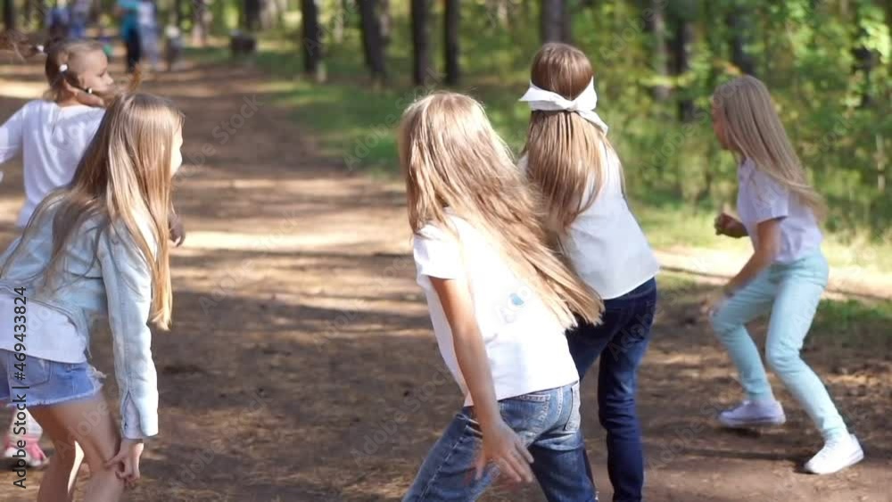 An active and cheerful group of children play hide and seek in a summer park. Outdoor games. Summer season. An active and cheerful group of children play hide and seek in a summer park. Outdoor games. Summer season.