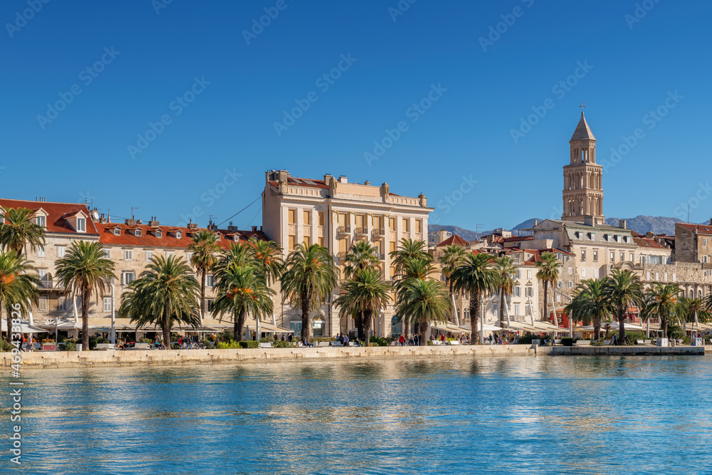 Beautiful view of waterfront promenade in old town Split with cafe, restaurants and palm trees and the Diocletian's Palace in Adriatic sea coast, Split, Croatia. Beautiful view of waterfront promenade in old town Split with cafe, restaurants and palm trees and the Diocletian's Palace in Adriatic sea coast, Split, Croatia.