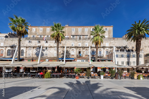 Old town of Split with stone wall, palm trees, cafe and restaurant in Riva promenade, Split, Croatia. 