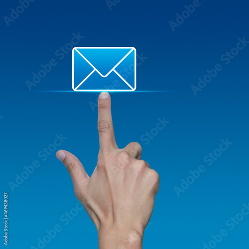 Hand pressing email flat icon over light blue gradient background, Business contact us online concept